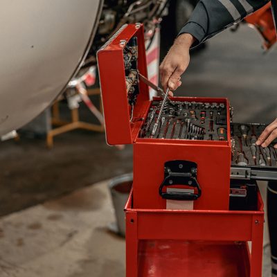 Male mechanic using instrument box in hangar